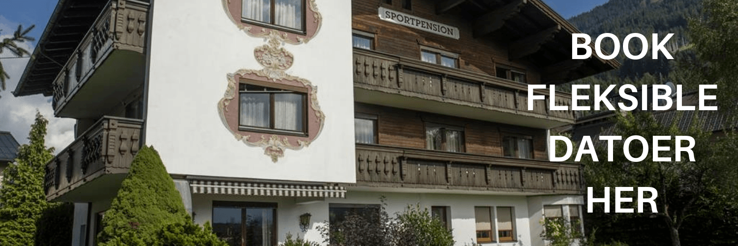 Et traditionelt alpehotel med træbalkoner og dekorative hvide vægge, beliggende i det frodige grønne område og bjergene i Westendorf. Perfekt til skiferie, teksten lyder BOOK FLEKSIBLE DATOER HER.