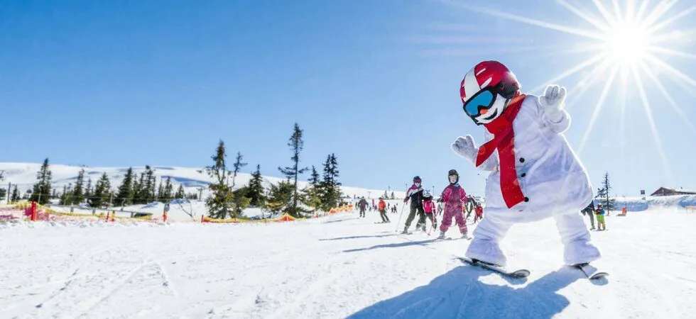 Skiferie i Norge - Skilærer i snemandsdragt underviser børn på skiskole