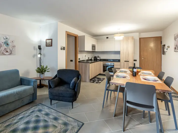 Stue og køkken i Condominio Giulia lejlighed med spisebord og sofa.