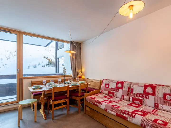 Rummelig Home Club lejlighed med spisebord og sofa, med udsigt til snelandskabet.